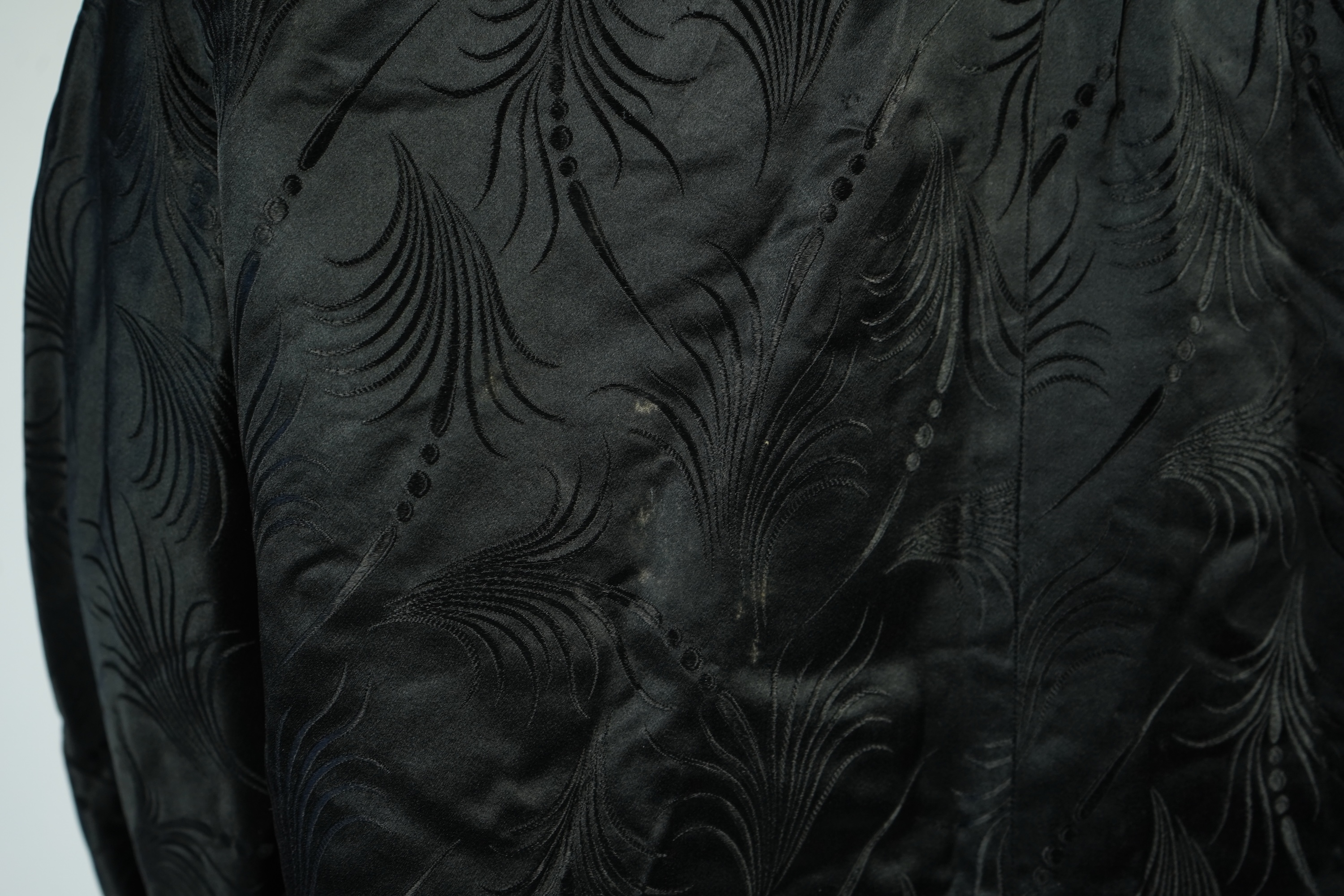 A 20th century ladies black silk damask opera coat, trimmed with a white fur collar and pink silk stripe brocade lining. 116cm from shoulder to hem. Condition - seams unstitched in places, small nick to black brocade by